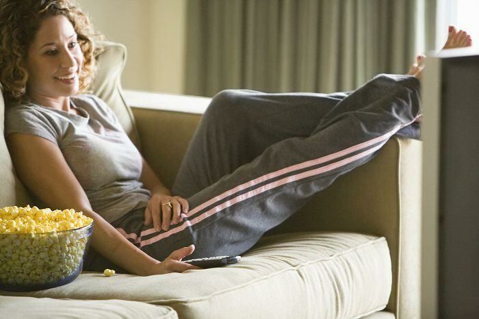 Woman relaxing with feet up on couch watching TV